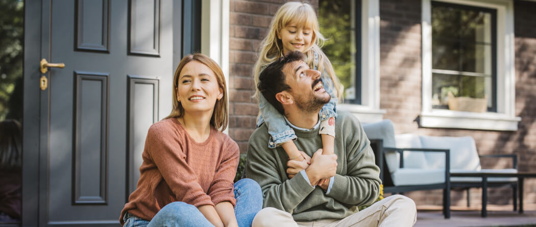 young family sitting on a front porch 