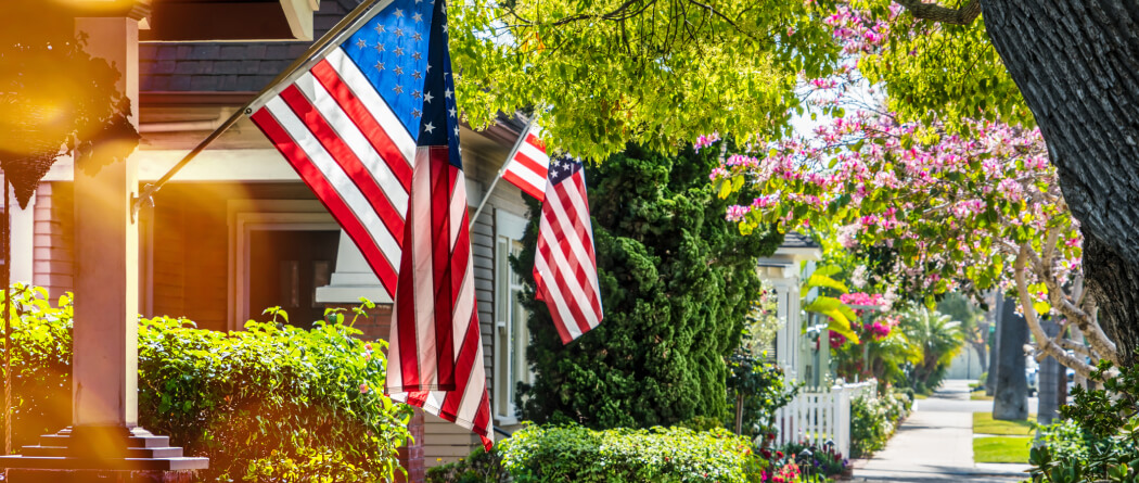 american flags on the front of suburban homes